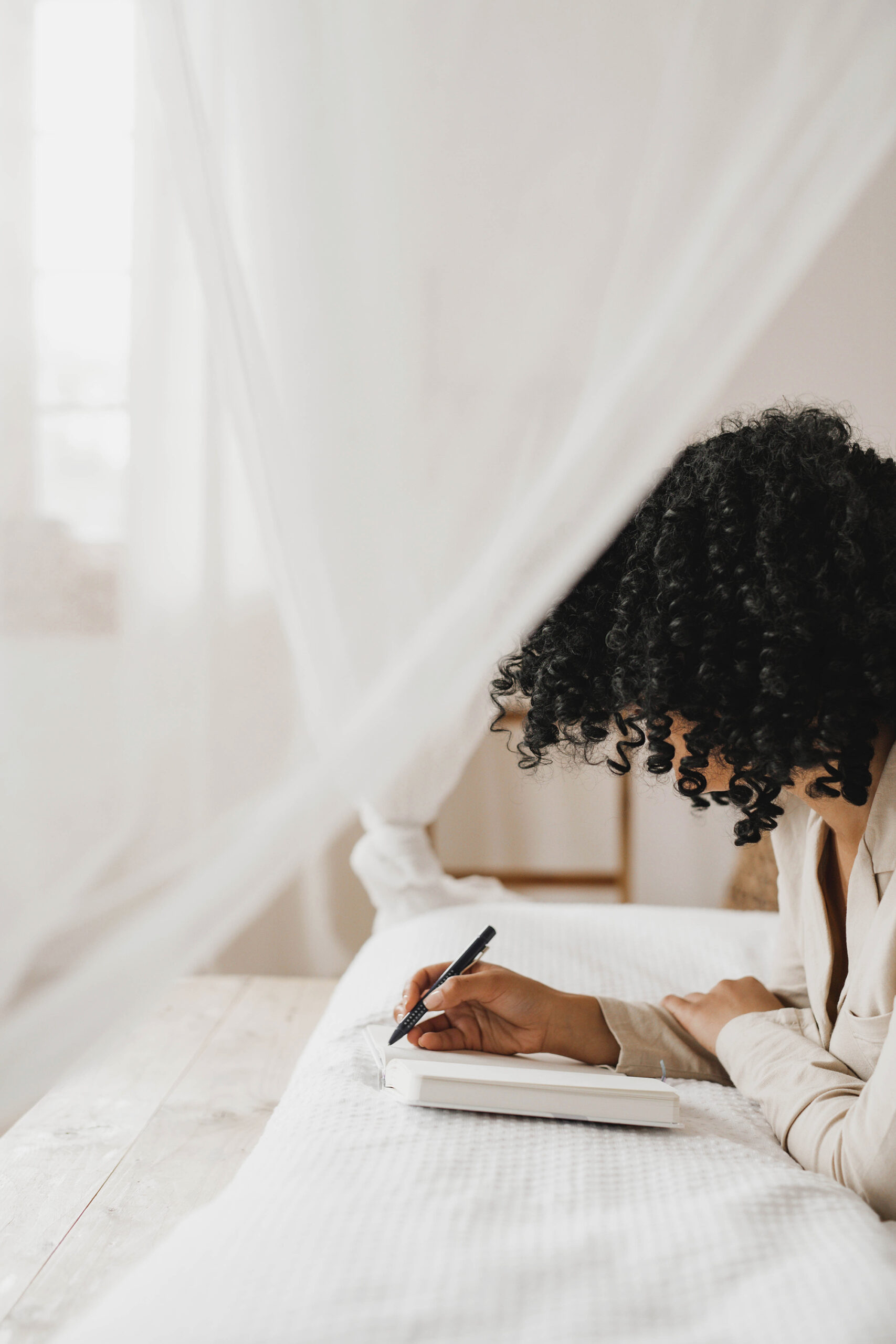 an image of a woman journaling on a bed on a blog about maternal mental health.