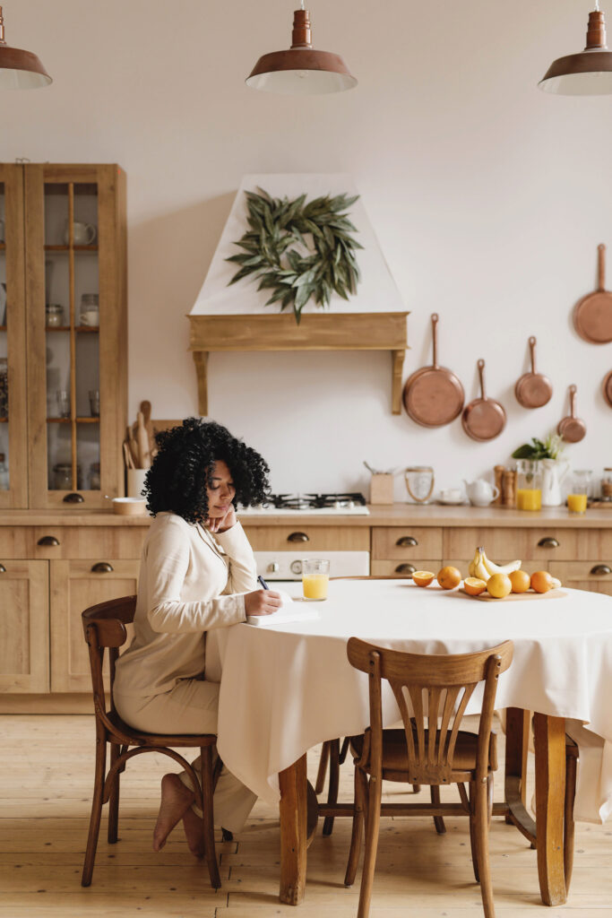 an image of a woman sitting at a table on a blog post about self-care for busy moms