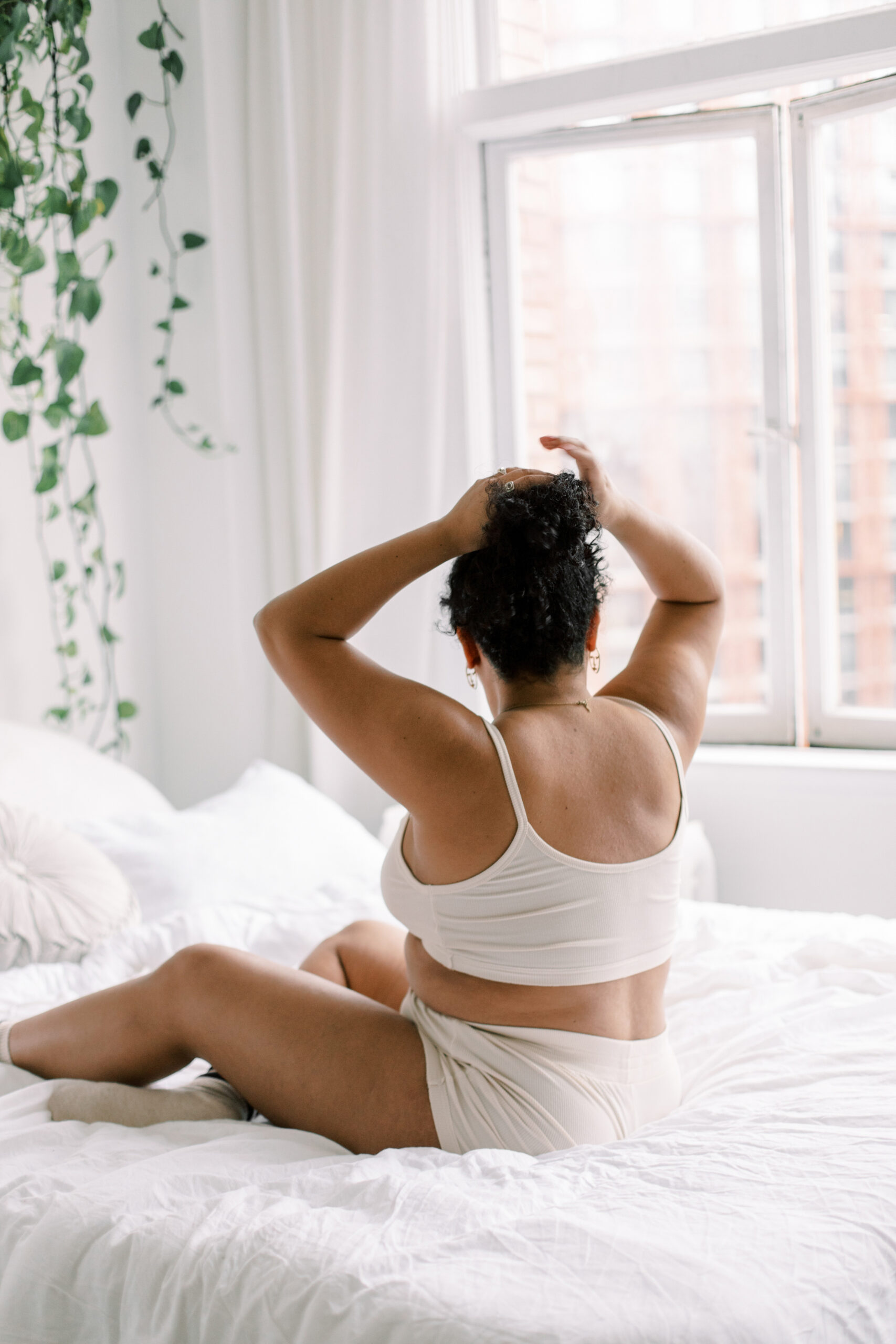 Image of a woman on a bed on a blog about burnout in motherhood for moms struggling with perfectionism.